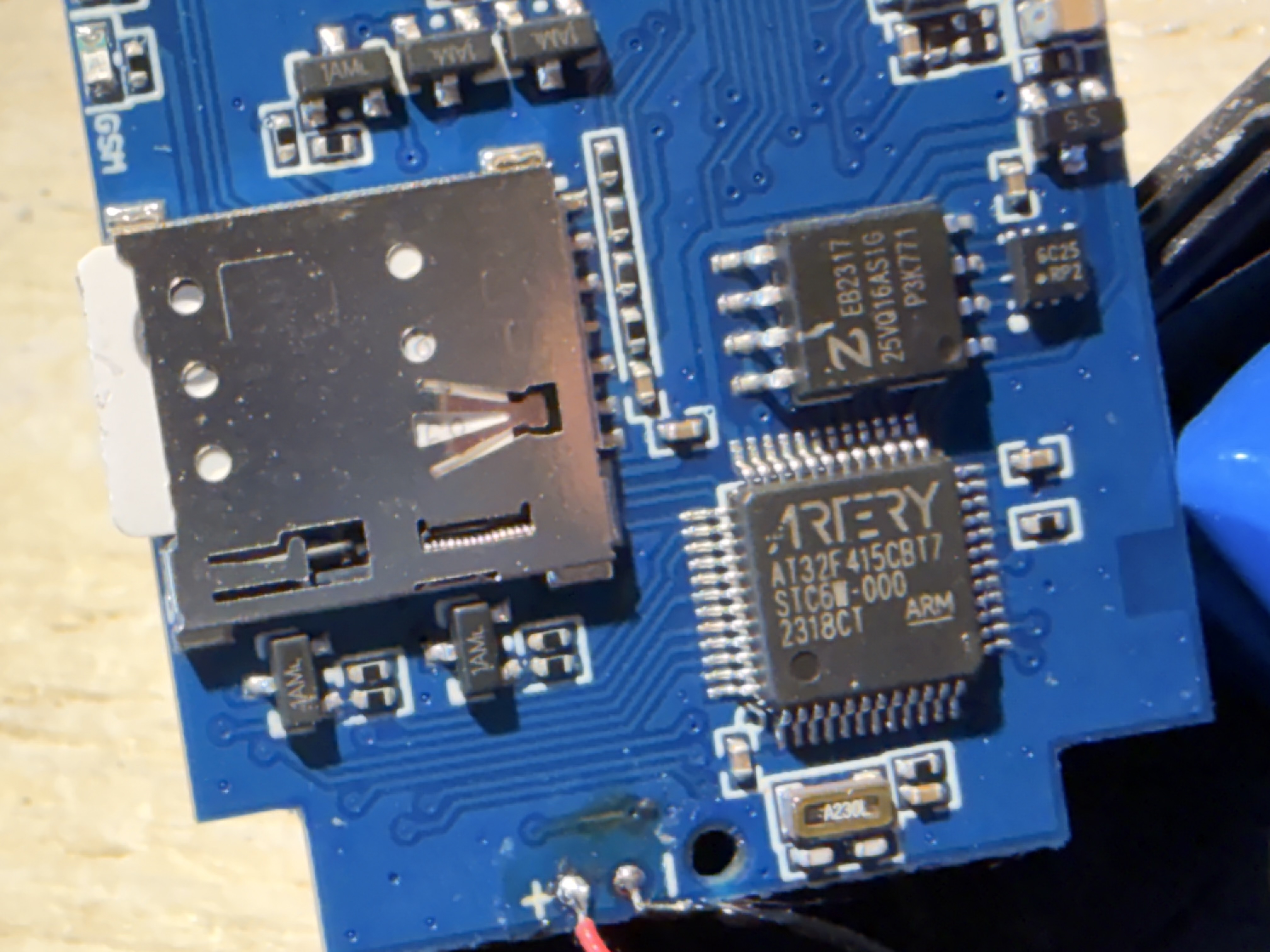 Close-up MCU Artery AT32F415CBT7 (datacode 2318CT) + SPI Flash W25Q16JV — STESSO stack hardware del PT60-L EU915!
