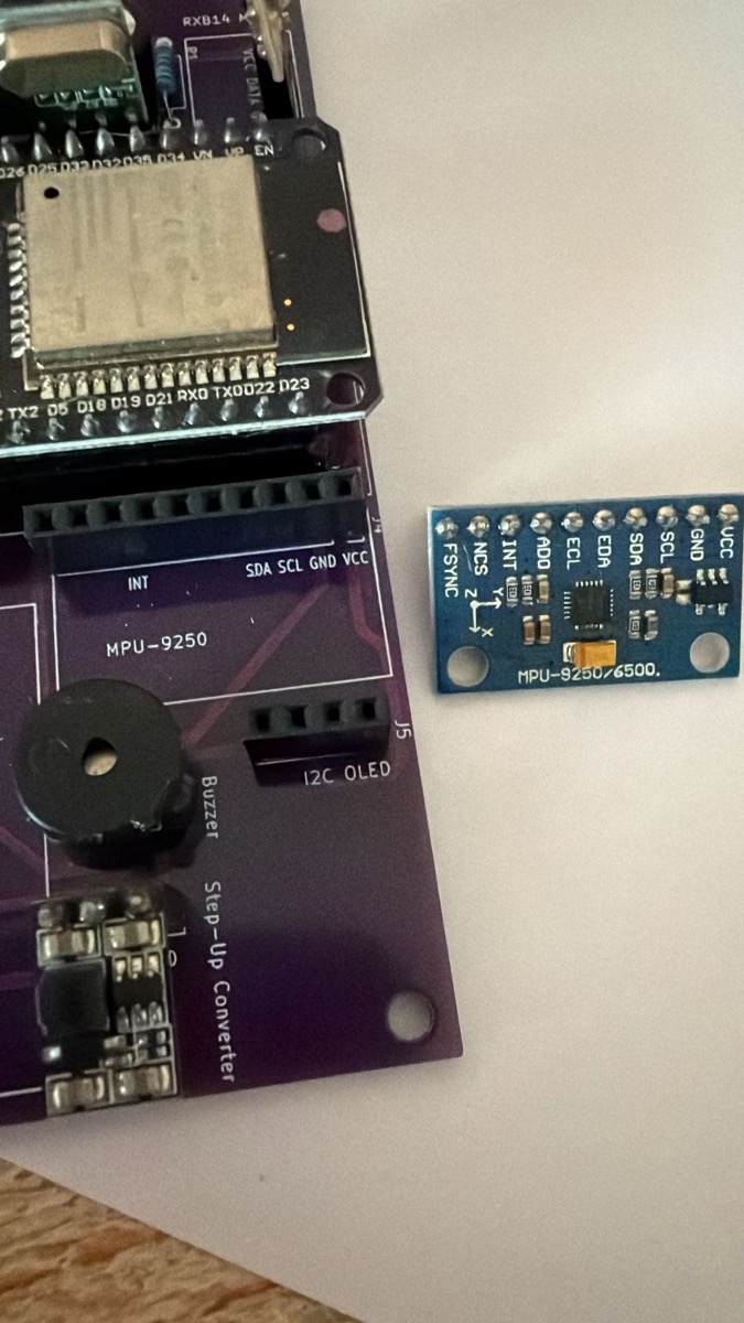 Area MPU-6500 IMU (I2C 0x68) + Buzzer piezo (GPIO18 PWM 2kHz) + Step-up converter